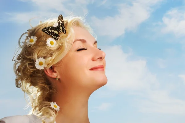 Прекрасная женщина с бабочкой над голубым небом — стоковое фото