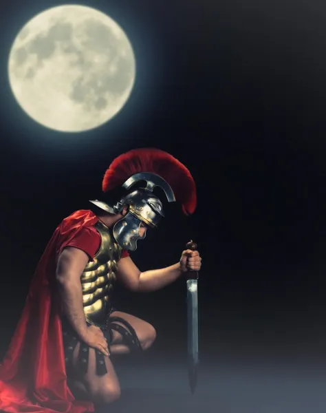 Солдат-легионер, стоящий ночью на коленях — стоковое фото