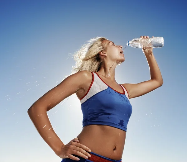 Young woman drinking water after fitness exercise — Stock Photo, Image