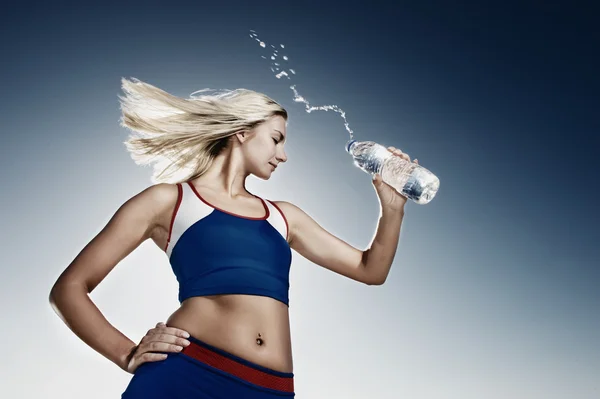 Mujer joven bebiendo agua después del ejercicio físico — Foto de Stock