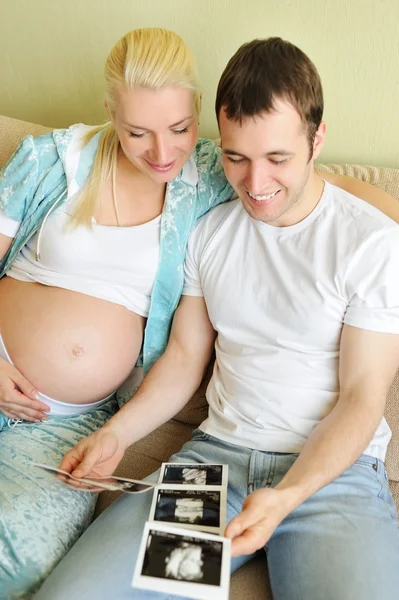 Giovane coppia in possesso e guardando una scansione ad ultrasuoni della loro attesa b — Foto Stock