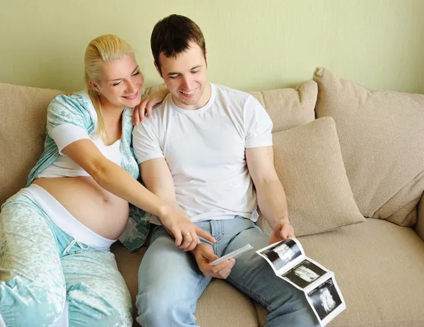 Giovane coppia in possesso e guardando una scansione ad ultrasuoni della loro attesa b — Foto Stock