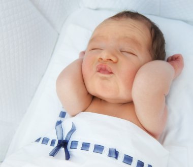 Sleeping baby making funny face clipart