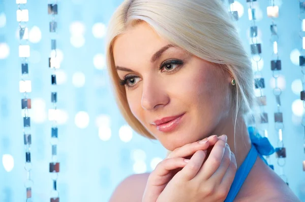 Vacker blond kvinna över abstrakt blå bakgrund — Stockfoto