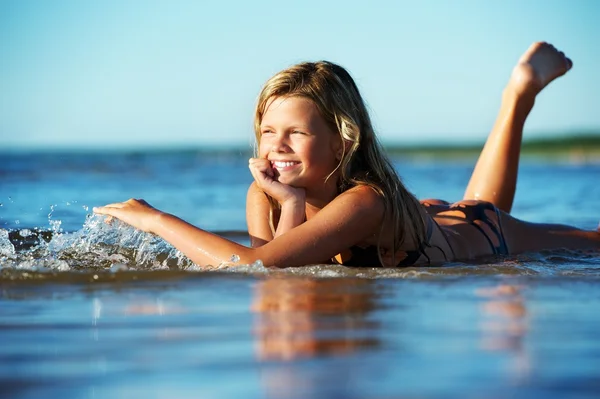 Gelukkig meisje liggen in het water — Stockfoto