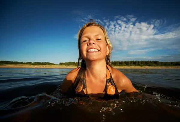 Gelukkig meisje zwemmen in het water — Stockfoto