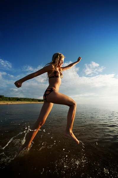Chica feliz corriendo en el mar — Foto de Stock