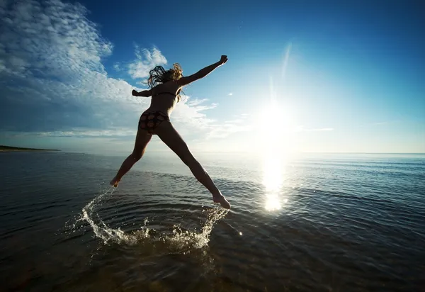 Fille sautant dans la mer — Photo