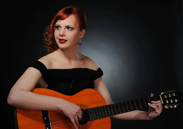 Vacker rödhårig kvinna spela gitarr — Stockfoto