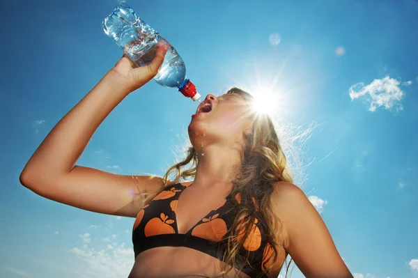 Молода дівчина п'є воду на відкритому повітрі — стокове фото