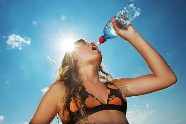Молода дівчина п'є воду на відкритому повітрі — стокове фото