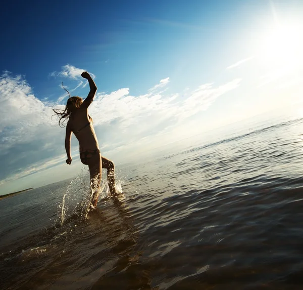 Счастливая девочка, бегущая в море — стоковое фото