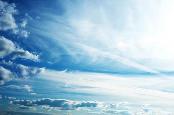 Blauwe lucht met pluizige wolken — Stockfoto