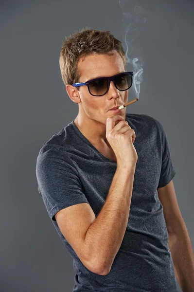 Jeune homme élégant fumant une cigarette — Photo