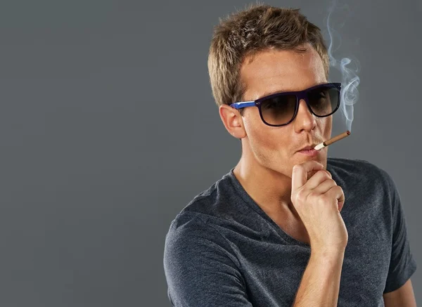 Молодий стильний чоловік курить цигарку — стокове фото