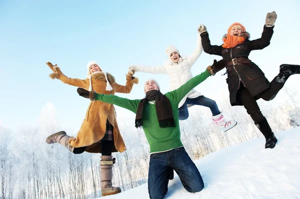 Glückliche Freunde springen in den Schnee — Stockfoto