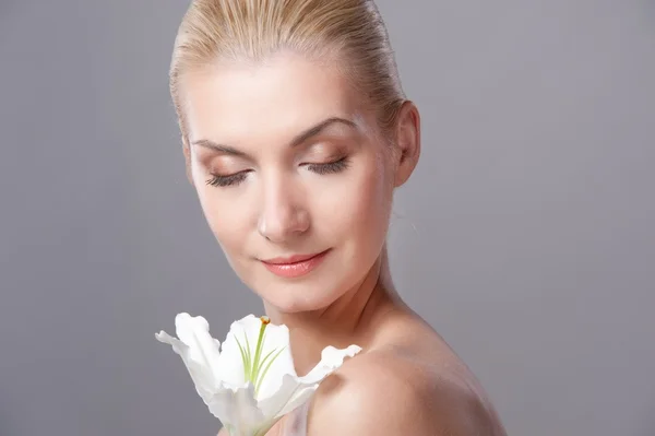Schöne blonde Frau mit weißer Lilienblüte — Stockfoto