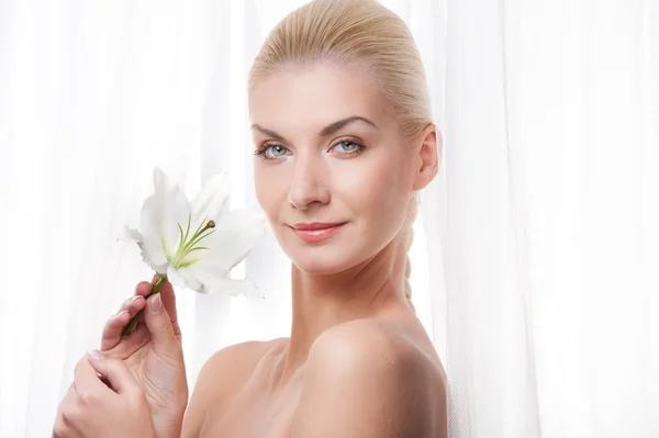 Schöne blonde Frau mit weißer Lilienblüte — Stockfoto