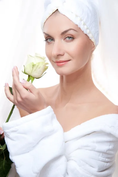 Mooie vrouw na douche houden een witte roos. — Stockfoto