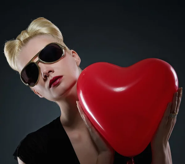 Attraktiv blond kvinna med en röd ballong — Stockfoto