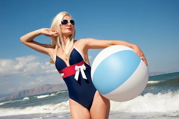 Pin up ragazza con una palla su una spiaggia — Foto Stock