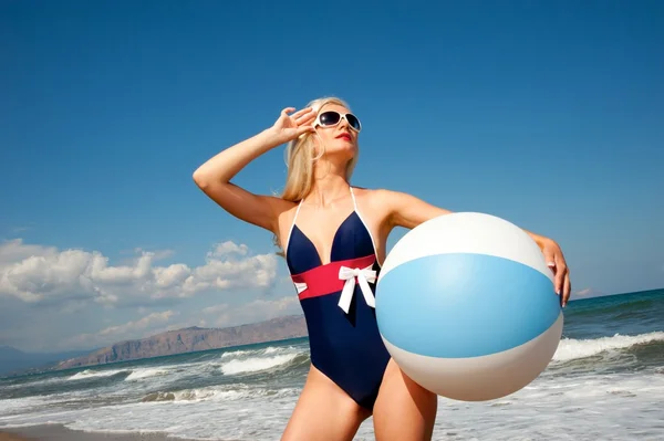 Pin up chica con una pelota en una playa — Foto de Stock