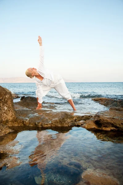 Mujer joven haciendo ejercicio de yoga al aire libre — Foto de Stock