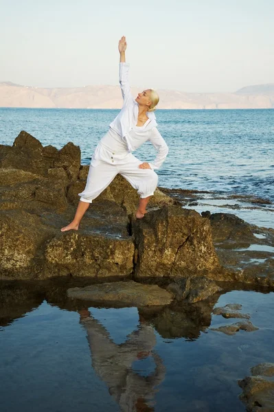 Hermosa joven haciendo ejercicio de yoga al aire libre — Foto de Stock