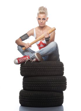 Punk girl sitting on a tires. clipart