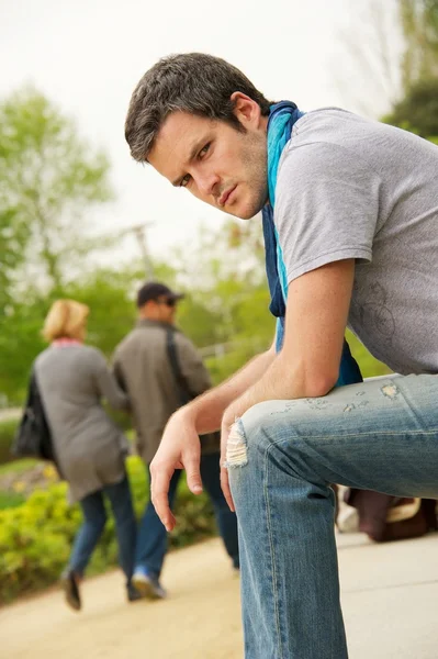 Young man and walking couple on a blurred background — Stock Photo, Image