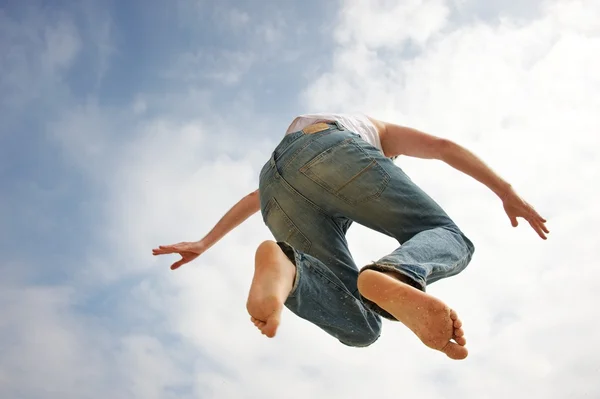 Mann springt gegen blauen Himmel — Stockfoto