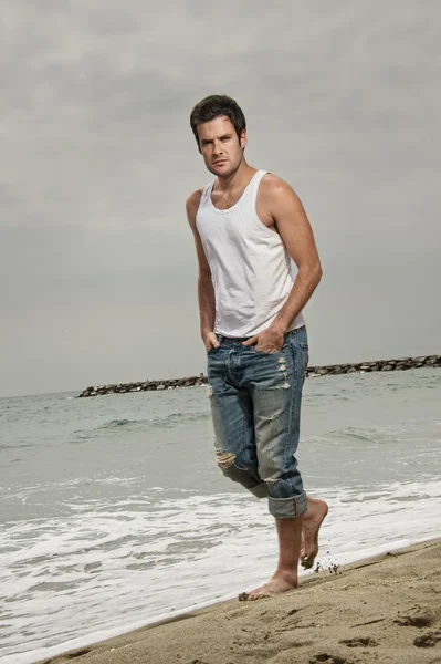 Schöner Mann zu Fuß am Strand — Stockfoto