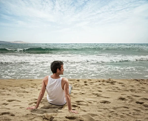 Schöner Mann entspannt sich am Strand — Stockfoto