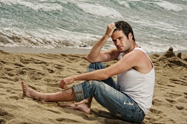 Красивый мужчина отдыхает на пляже — стоковое фото