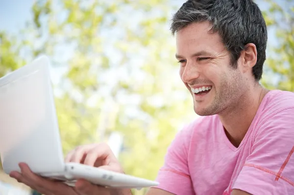 Homem bonito com laptop ao ar livre — Fotografia de Stock