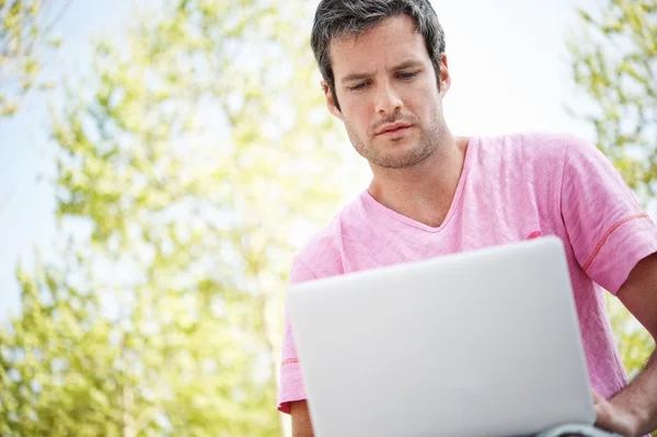 Homem bonito com laptop ao ar livre — Fotografia de Stock
