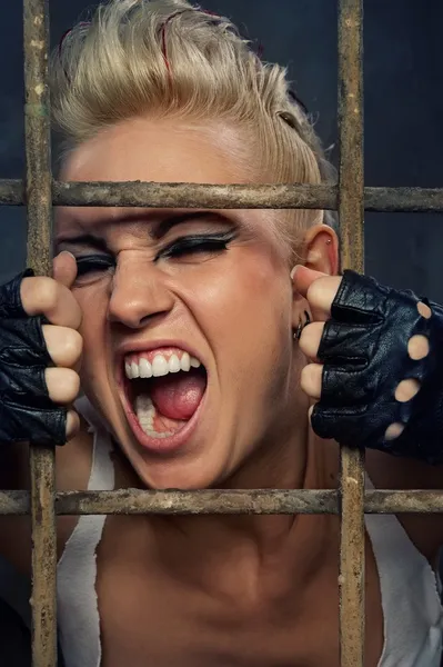 Punk girl screaming behind bars — Stock Photo, Image