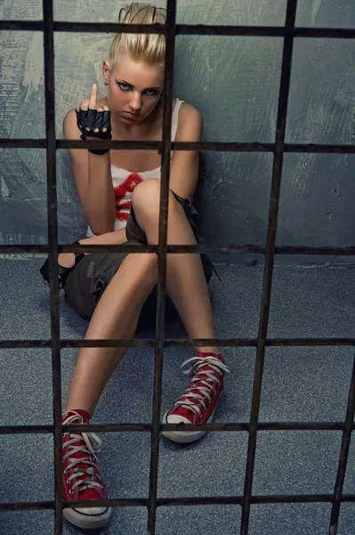 Punk menina mostrando dedo do meio atrás das grades — Fotografia de Stock