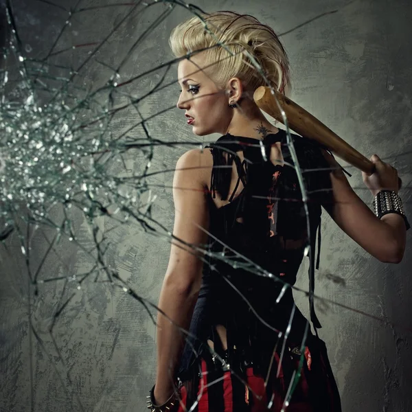 Punk girl with a bat behind broken glass — Stock Photo, Image