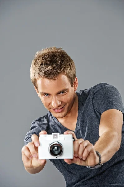 Jovem homem bonito com uma câmera — Fotografia de Stock