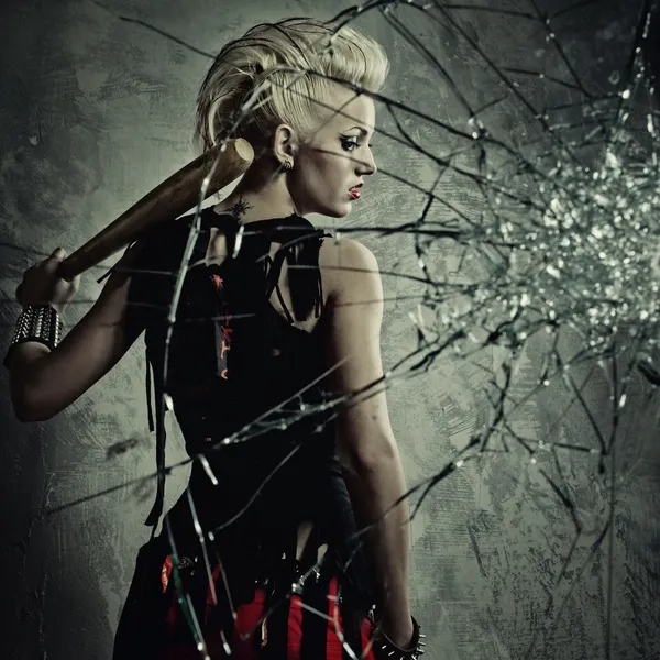 Punk chica con un bate detrás de cristales rotos — Foto de Stock