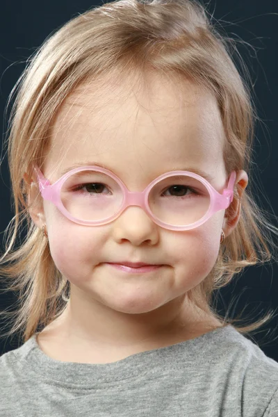 Aranyos kis lány portréja a rózsaszín szemüveg — Stock Fotó