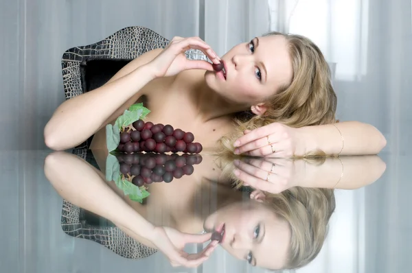 Linda loira está comendo uva — Fotografia de Stock