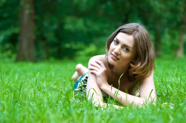 Hermosa mujer está acostada en la hierba — Foto de Stock