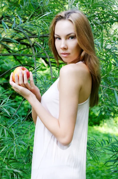 Beautiful woman with apple in the forest — Stock Photo, Image