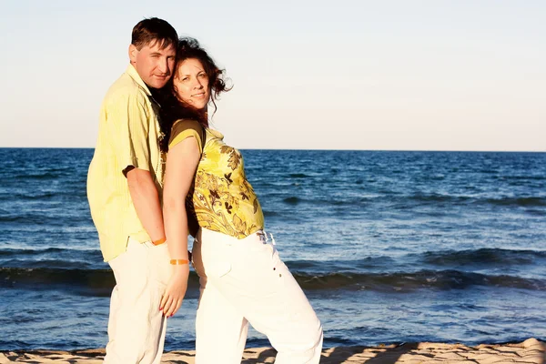 Muž a žena pár v romantické objetí na pláži — Stock fotografie