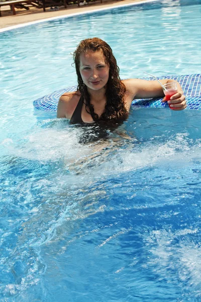 Дівчина з коктейлем у басейні — стокове фото