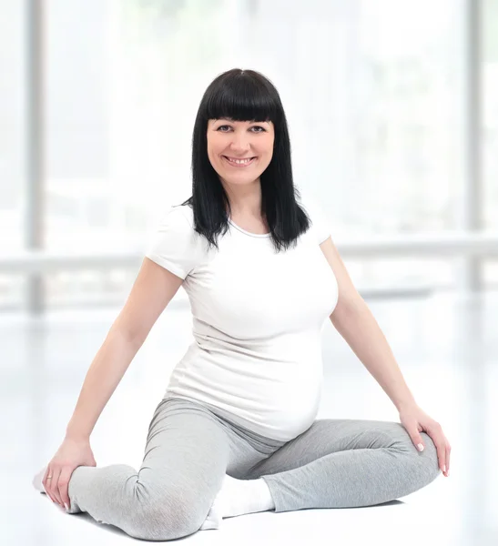Terhes nő ül a földön, az aerobik órák — Stock Fotó