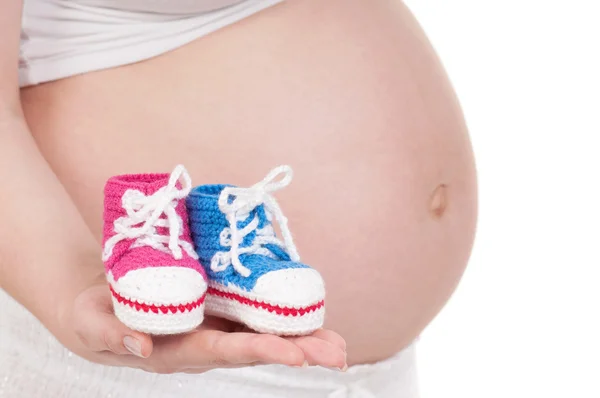 Schwangere mit Babystiefeln — Stockfoto