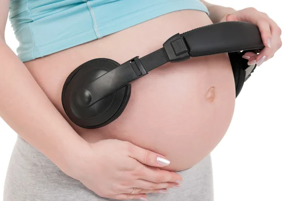 Zwangere buik met koptelefoon — Stockfoto